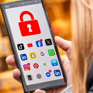 Fotomontage: Schülerin mit Handy auf dessen Display Social Media-Apps und ein rotes Schloss zu sehen sind.