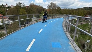 Der Belag auf der beheizten Fahrradbrücke in Tübingen wurde repariert. Zu erkennen ist die reparierte Stelle an einem Rechteck in hellerem Blau, verglichen mit dem Rest der Fahrbahn.