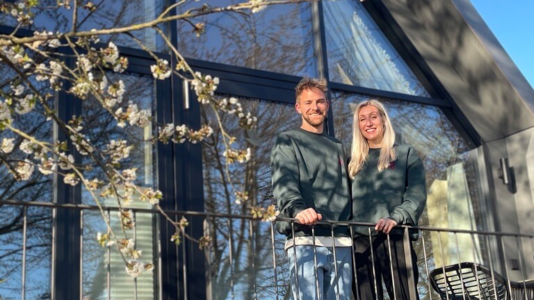 Peter und Silke Rombach auf dem Balkon einer Lodge ihres Schwarzwald Hotel für Schwarzwald Urlaub.