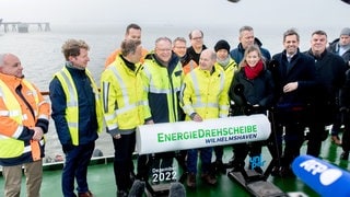 Bundeskanzler Olaf Scholz (SPD) mit Christian Lindner (FDP), Bundesminister der Finanzen, Robert Habeck (Bündnis 90Die Grünen), Bundesminister für Wirtschaft und Klimaschutz, und Stephan Weil (SPD), Ministerpräsident in Niedersachsen, auf dem Spezialschiff "Höegh Esperanza". In Wilhelmshaven wurde der erste Anleger für die Ankunft von Schiffen mit Flüssigerdgas fertiggestellt; das LNG-Terminal wurde am 17. Dezember 2002 in Betrieb genommen.