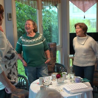 Frauen stehen in einem Wintergarten