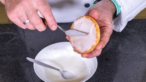 Die Amerikaner werden mit einem Zuckerguss glasiert, bevor das Gebäck dekoriert wird.