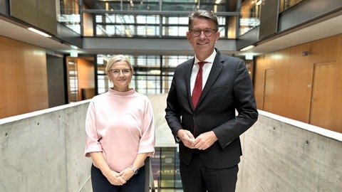 Korrespondentin Nicole Markwald und Kulturstaatsminister Wolfram Weimer stehen in der Halle im ARD-Hauptstadtstudio nebeneinander und schauen in die Kamera