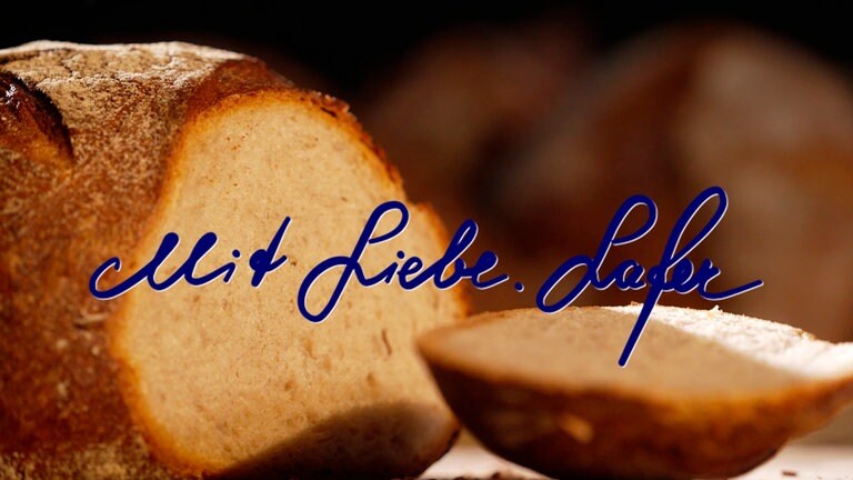 Montage des eigenhändig von Johann Lafer geschriebenen Schriftzugs "Mit Liebe. Lafer" vor einem Laib Brot