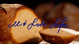 Montage des eigenhändig von Johann Lafer geschriebenen Schriftzugs "Mit Liebe. Lafer" vor einem Laib Brot