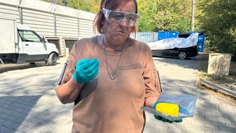 Eine Frau hat Sprengstoff Semtex in der Hand. Derselbe Sprengstoff wurde vor kurzem in einer Drohne am Flughafen LeipzigHalle gefunden.