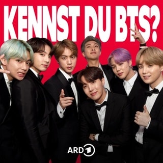 Mitglieder von BTS in schwarzen Sakkos