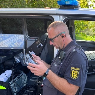 Ein speziell geschulter Polizeibeamter steuert die Drohne von einer mobilen Bodenstation aus und überwacht auf dem Bildschirm die Videoaufnahmen, mit denen Abstandsverstöße von Lastwagen dokumentiert werden.