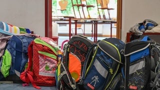 Schulranzen stehen vor einem Klassenraum