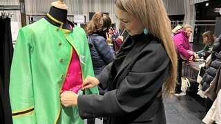 Eine Frau begutachtet ein Kleid beim Kostümverkauf bei den Bregenzer Festspielen.