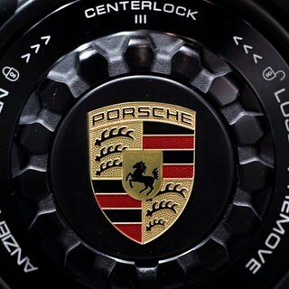 Das Porsche-Logo ist auf der Felge eines Sportwagens zu sehen.