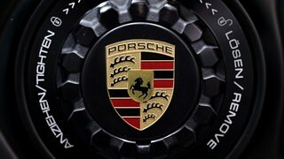 Das Porsche-Logo ist auf der Felge eines Sportwagens zu sehen.