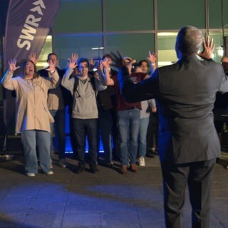 Mehrere Besucher des SWR Studios in Ulm jubeln an der Kulturnacht nach dem gelungenen Chor-Experiment.