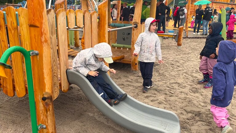 Kleine Kinder rutschen eine Rutsche herunter: Der Unisport der Rheinland-Pfälzischen Technischen Universität Kaiserslautern-Landau (RPTU) hat auf dem Campus einen Abenteuerspielplatz eröffnet. Das Kitz-Land können Kinder mit einer Unisport-Karte besuchen.