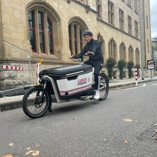 Ein Fahrradkurier vom LaborKoblenz unterwegs auf der Fahrradstraße in Koblenz