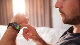 Symbolbild: Mann mit Schlaftracker im Bett