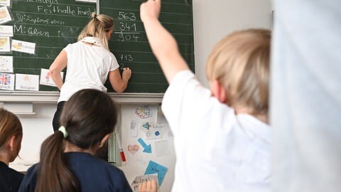 Schüler einer Grundschule arbeiten in einem Klassenzimmer an Mathematikaufgaben
