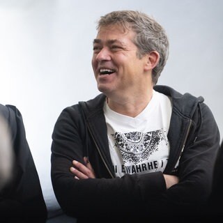 Michael Ballweg (r), Gründer der "Querdenken"-Bewegung, steht mit seinen Anwälten in einem Saal des Landgerichts Stuttgart. 