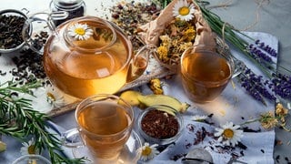 Getrocknete Blüten, Teekanne und Teegläser mit Tee