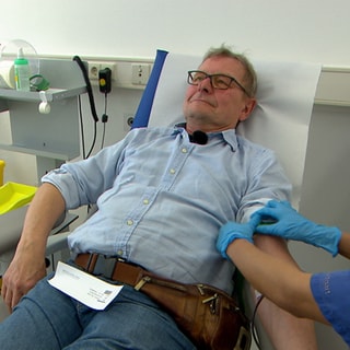 Michael Butz liegt auf einer Liege und spendet Blut.