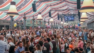 Zahlreiche Menschen feiern zum Auftakt des 86. Stuttgarter Frühlingsfests in einem Bierzelt.