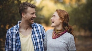 Ein junger Mann und eine junge Frau lächeln sich an | Wenn die Liebe endet: Funktioniert eine Freundschaft nach der Trennung?