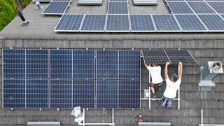 Auf einem Dach eines Privathauses wird eine PV Anlage zur Stromerzeugung installiert (Symbolbild)