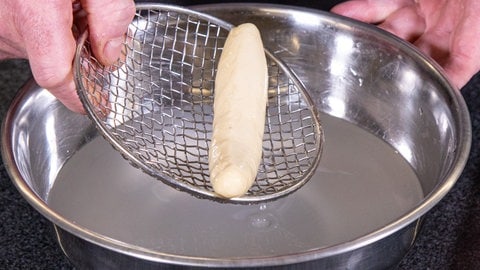Teig wird in Lauge gegeben.