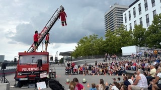 Die Straßenshow "FeuerWer?" vor Unwetterwolken: Das Straßentheaterfestival Ludwigshafen musste am Sonntag wegen eines Unwetters unterbrochen werden.