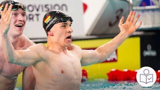 Johannes Liebmann reckt im Schwimmbecken beide Arme in die Höhe und freut sich über seinen Sieg. Hinter ihm sein Teamkollege Sven Schwarz. Rechts unten das SWR-Logo für Leichte Sprache.