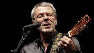 Der Musiker Reinhard Mey auf der Bühne mit Gitarre
