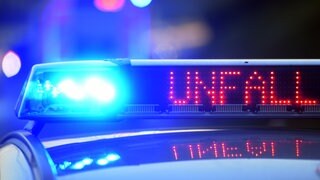 Auf einem Polizeifahrzeug warnt eine Leuchtschrift vor einer Unfallstelle (Symbolbild)