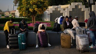 Passagiere, die durch die Schließung des internationalen Flughafens von Dubai gestrandet sind, warten auf dem Flughafenparkplatz in Dubai.