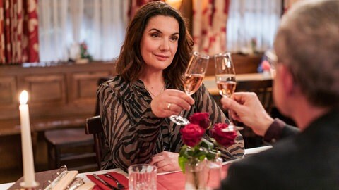 Monique (Anne von Linstow) und Bernhard (Karsten Dörr) stoßen im Löwen mit Sekt an