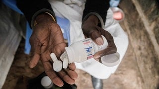 Eine Frau in Kenia nimmt ihre Medikamente: Die HIV-Therapie wird auch antiretrovirale Therapie genannt. Sie unterdrückt die Vermehrung der Viren im Körper. Die USA haben ihre Auslandshilfen drastisch gekürzt. Das hat für viele Menschen Folgen.
