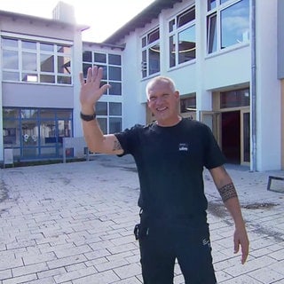 Hausmeister Carsten Wagner aus Ulm winkt.