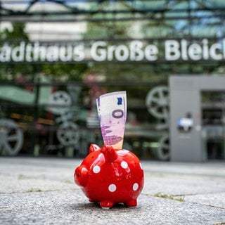In einem Sparschwein vor dem Mainzer Rathaus steht ein Sparschwein, in dem ein 0-Euro-Schein steckt.