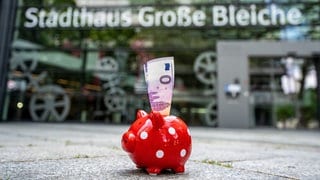 In einem Sparschwein vor dem Mainzer Rathaus steht ein Sparschwein, in dem ein 0-Euro-Schein steckt.