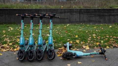 Geparkte und umgestürzte Dott E-Scooter im Herbst.