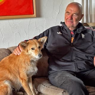 Hündin Luna mit ihrem Herrchen Les Johnson auf der Couch