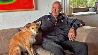 Hündin Luna mit ihrem Herrchen Les Johnson auf der Couch