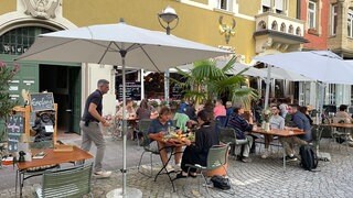 Gäste sitzen an den Tischen vor dem Gasthaus Gutenberg in Karlsruhe.