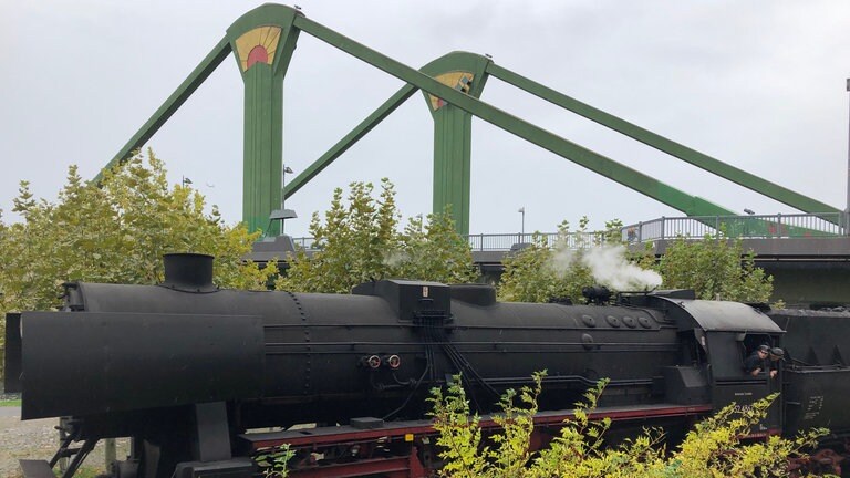 Die Dampfeisenbahn fährt direkt am Mainufer entlang und unter zahlreichen Brücken durch wie hier der Flößerbrücke. 