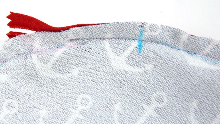 Die Naht kann auch so geschlossen werden, dass sie auf einer Strecke von ca. 5 mm parallel und möglichst nahe zur Reißverschlussnaht verläuft.