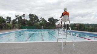 Ein Bademeister sitzt vor einem Schweizer Freibad.