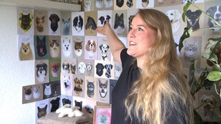 Alicia Härter sthet vor einer Wand aus Tierportraits. Jedes Porträt, das sie gezeichnet hat, bekommt hier einen Platz. 