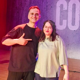 Özcan Cosar und Landesschau-Zuschauerin Hannah stehen Arm in Arm auf einer Bühne.