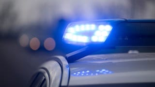 Ein Blaulicht blinkt an einem Fahrzeug der Polizei.