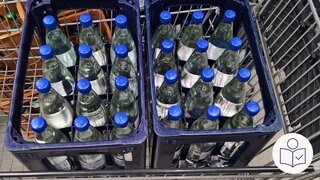 Zwei Kisten mit Minerals·wasser stehen in einem Einkaufswagen. Die Firmen stellen mehr Mineral·wasser her. Der Grund ist die Hitze. Rechts das SWR Logo für Leichte Sprache.