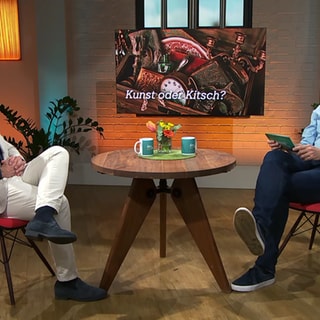 Auktionator Ferdinand Eppli bewertet Gegenstände von Zuschauerin.